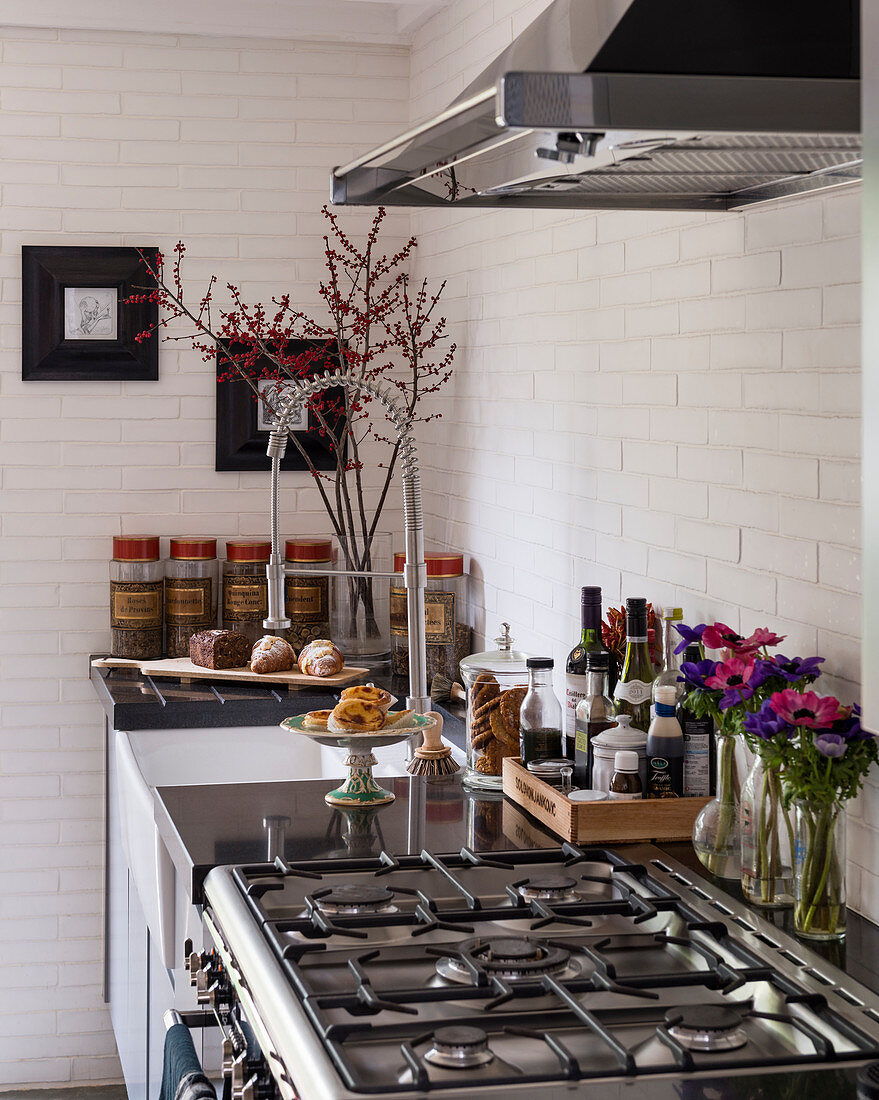 Gas cooker in kitchen with white brick wall