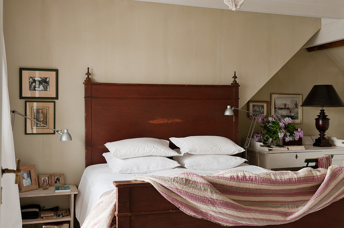Kissen und Decke auf Doppelbett aus Holz im Schlafzimmer