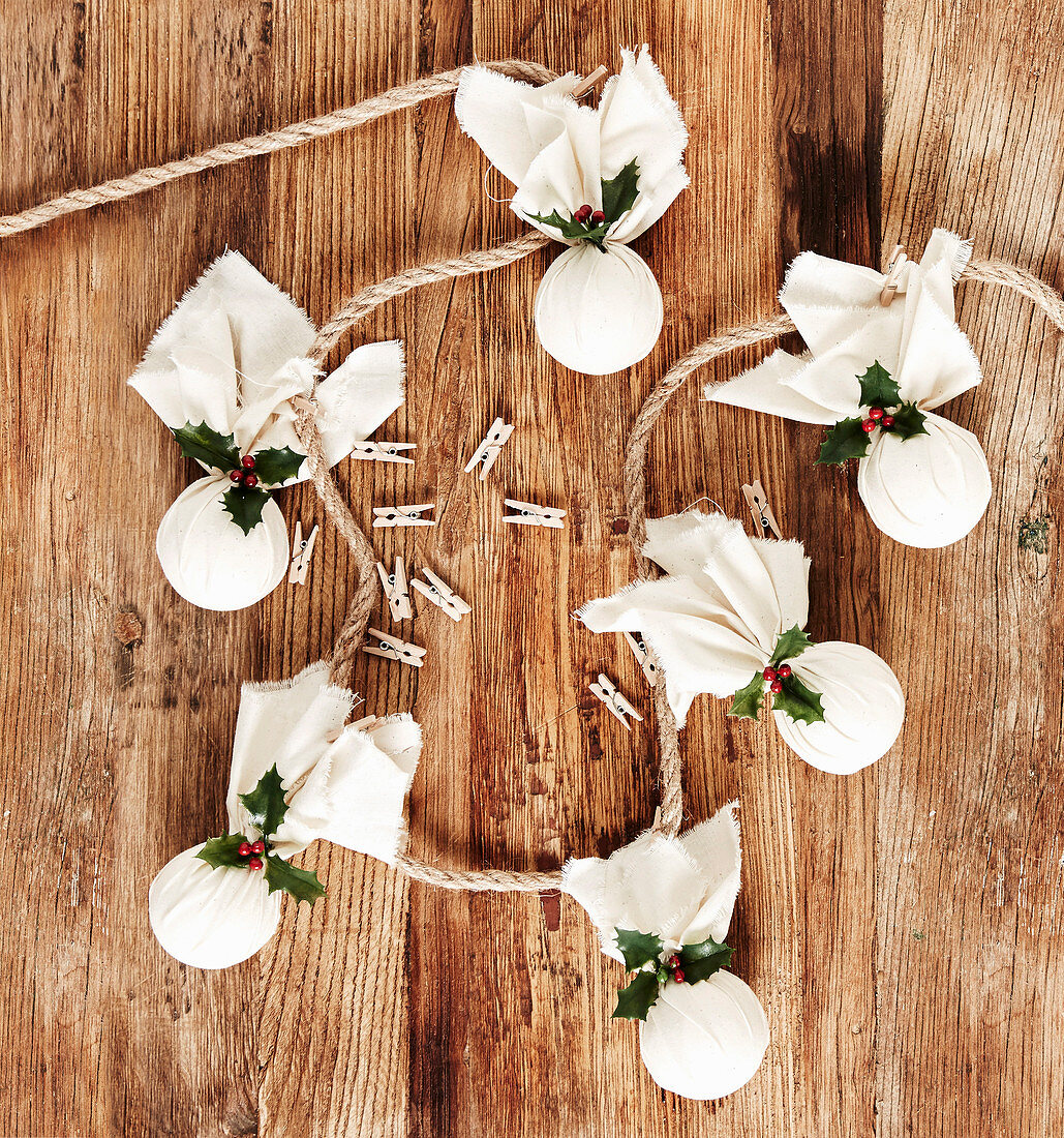 Garland of handmade Christmas pudding decorations wrapped in cloth