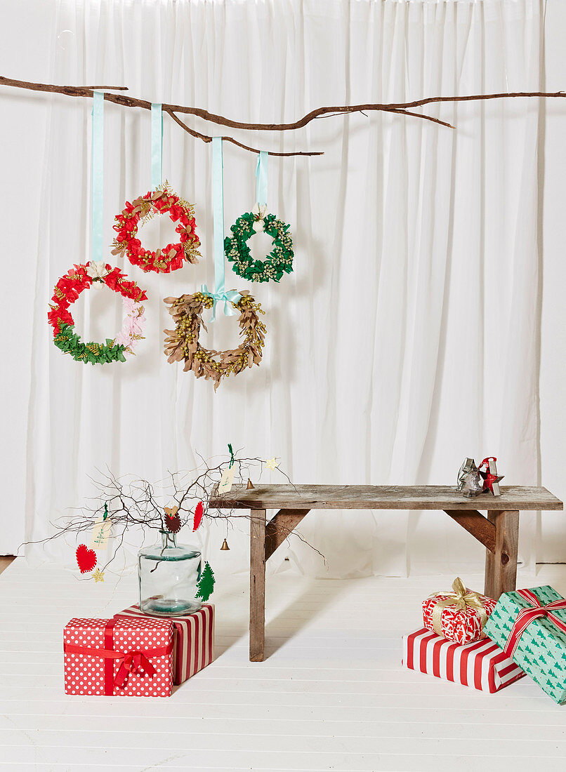 DIY-Weihnachtskränze aus Stoffresten, Holzbank und verpackte Weihnachtsgeschenke
