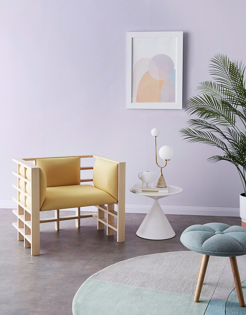 Designerstuhl, Beistelltisch und Hocker im Zimmer mit fliederfarbener Wand