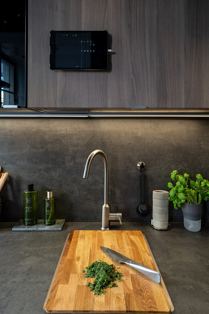 Chopped herbs on wooden chopping board in grey kitchen