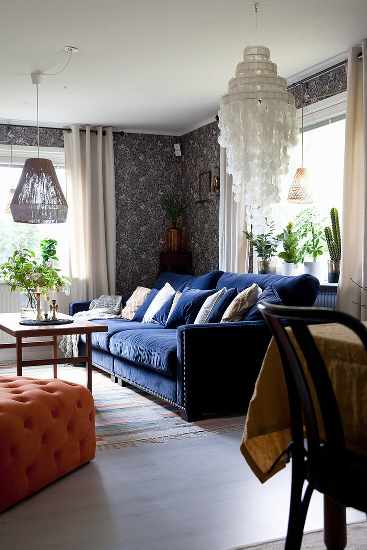 Dark blue sofa and vintage-style wallpaper in living room