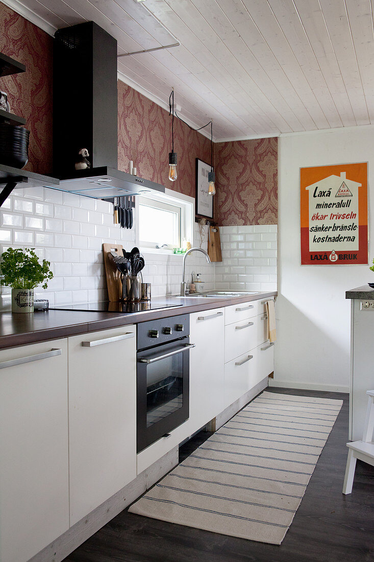 Subway tiles and vintage-style wallpaper in kitchen