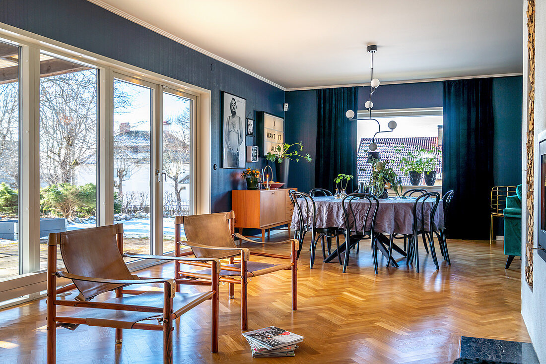 Classic chairs and dining area in open-plan interior with blue walls