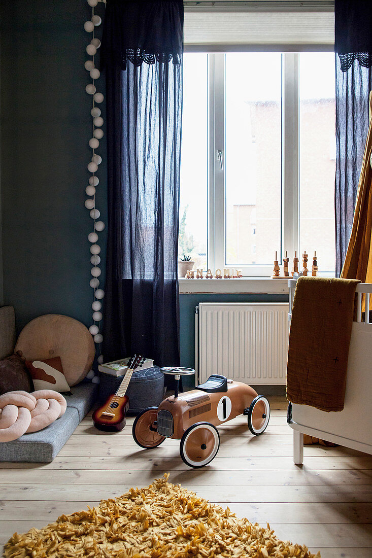 Kinderzimmer in Blautönen mit Holzbobbycar