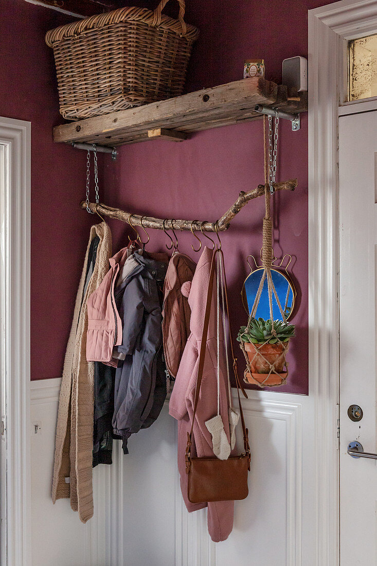 Plant hanger suspended from DIY coat rack on pink wal