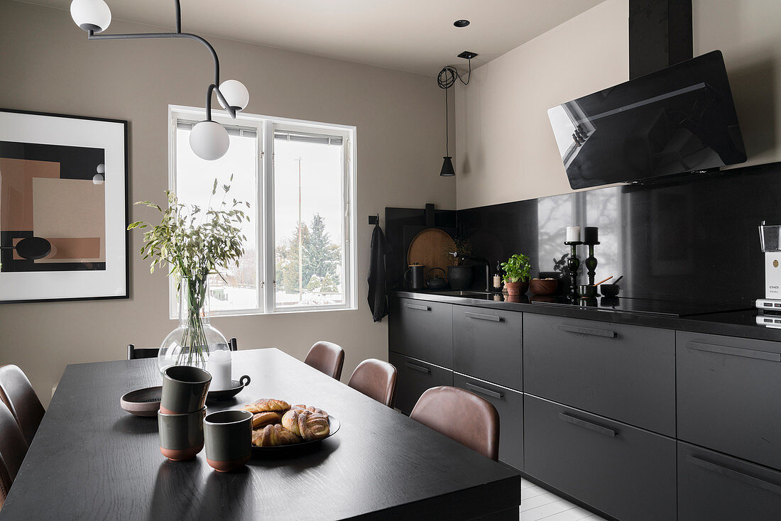 Esstisch in der Wohnküche mit schwarzer Küchenzeile