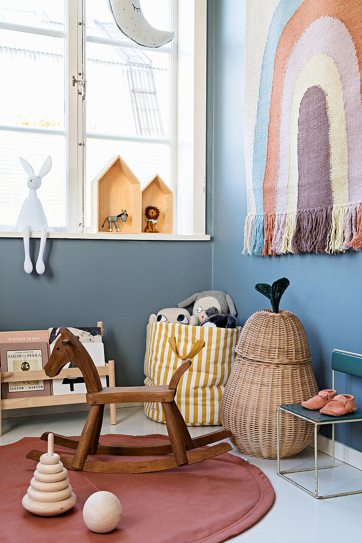 Rocking horse and vintage accessories in nursery in muted shades
