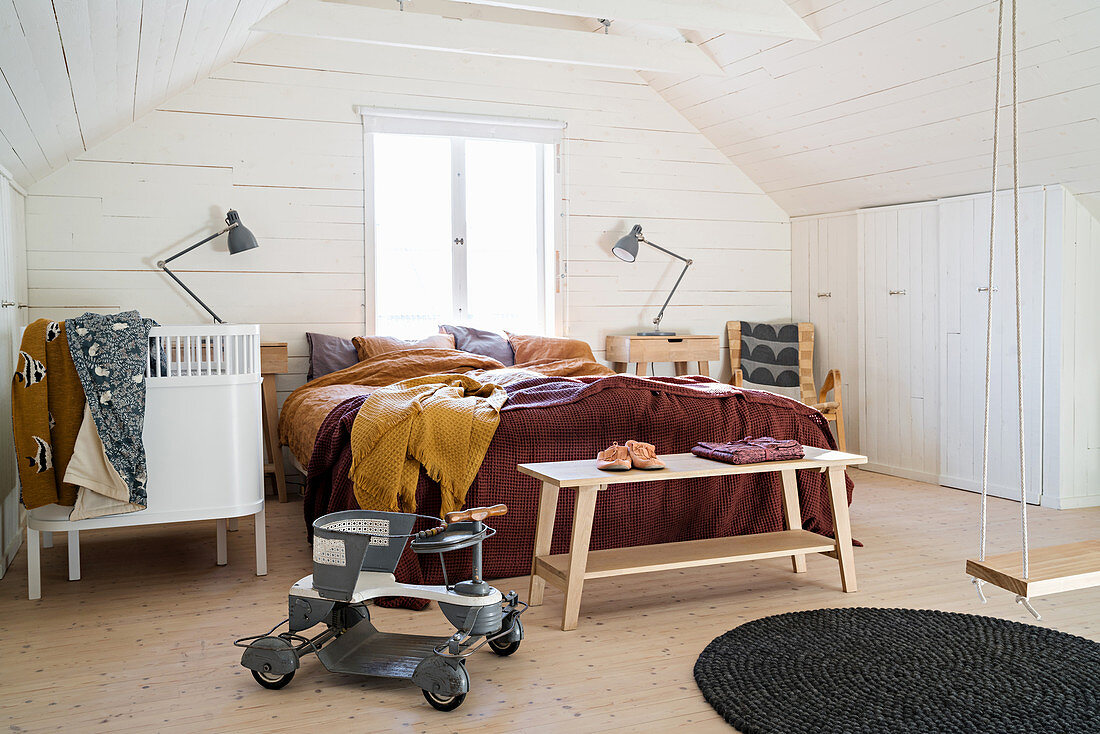Schlafzimmer unterm Dach mit Schränken im Kniestock und Babybett