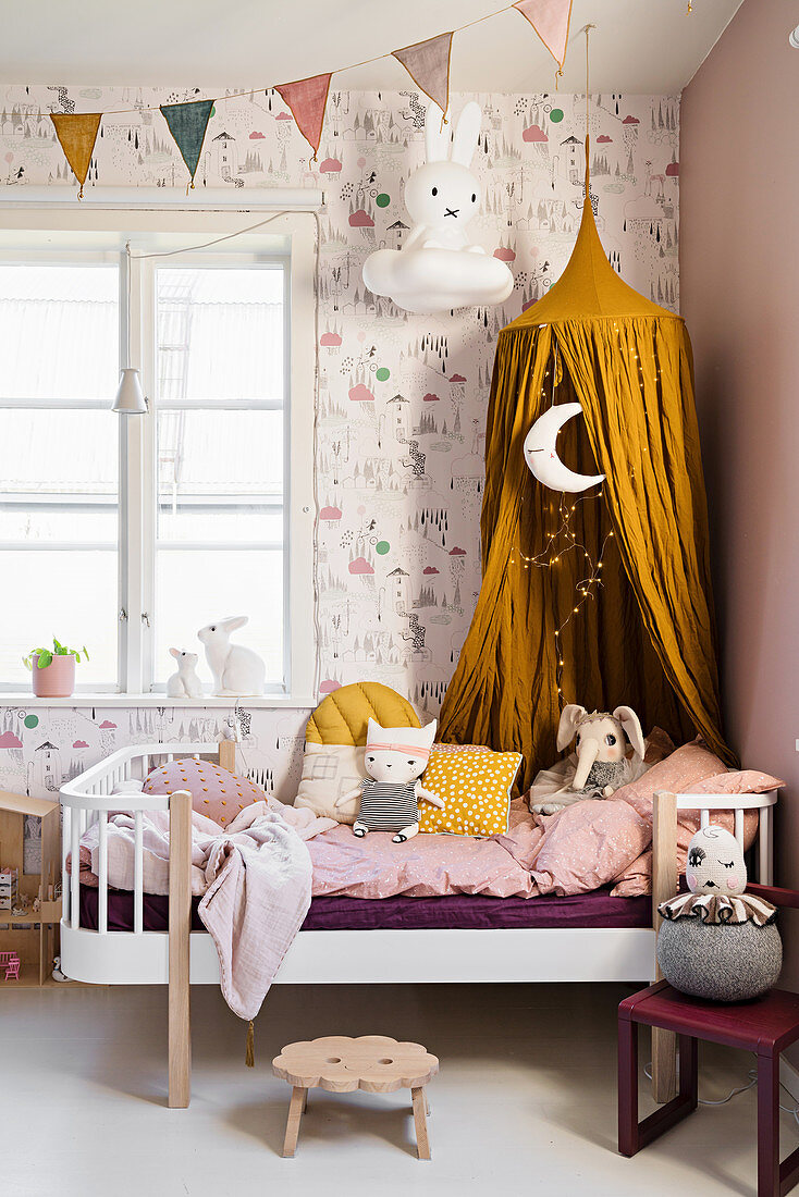 Mustard-yellow canopy above bed in little girl's bedroom