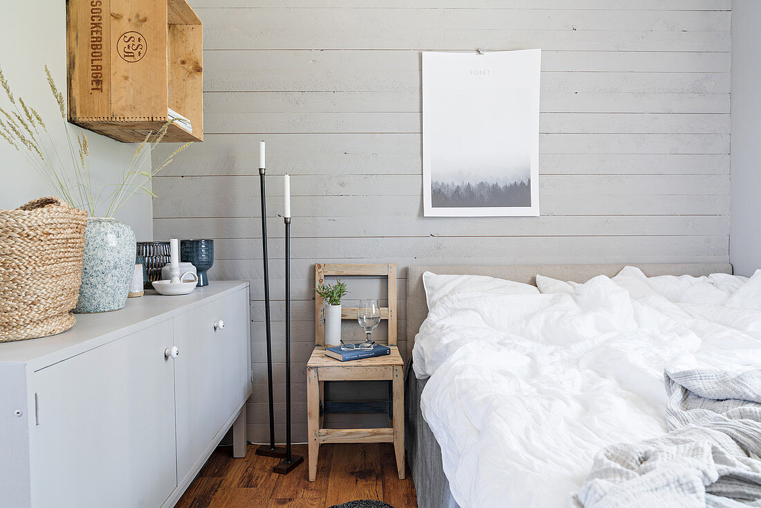 Rustikales Schlafzimmer mit grauer Bretterwand hinterm Bett