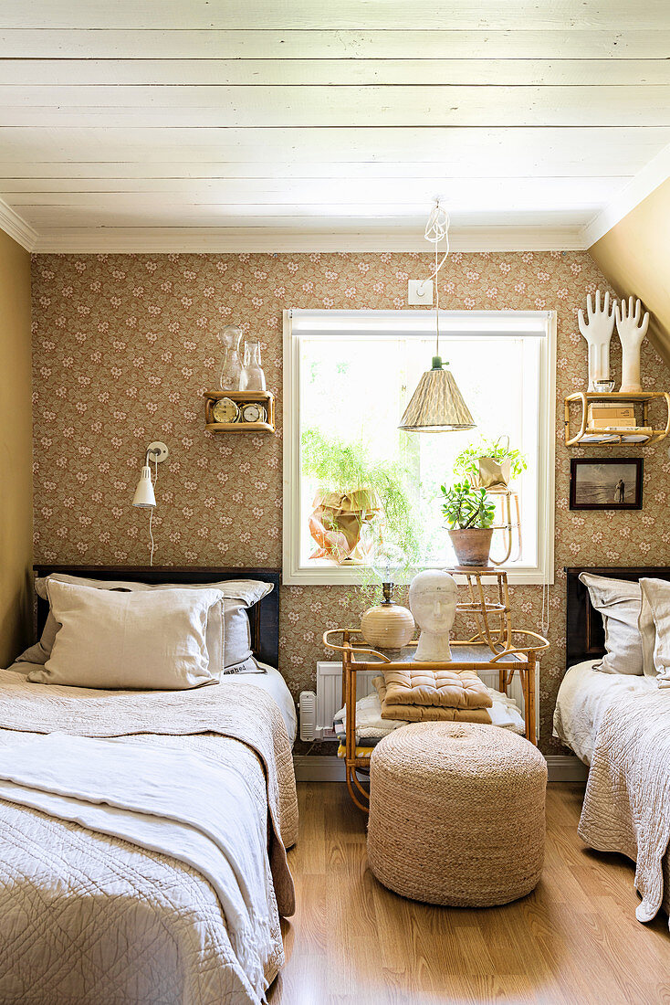 Twin beds flanking window in vintage-style beige bedroom