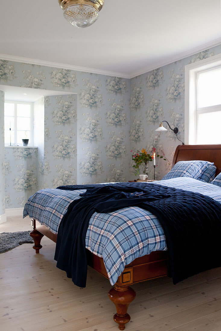 Antikes Holzbett in Schlafzimmer mit nostalgischer Blumenmustertapete