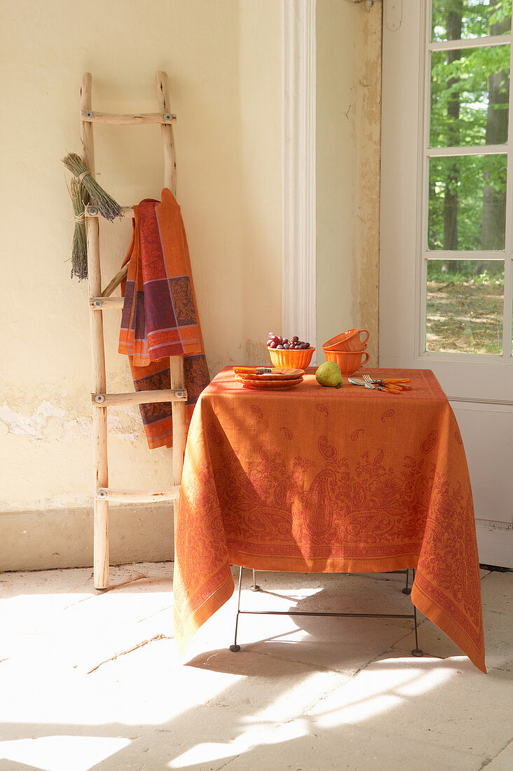 Tisch mit orangefarbenem Tischtuch und spätsommerlicher Deko