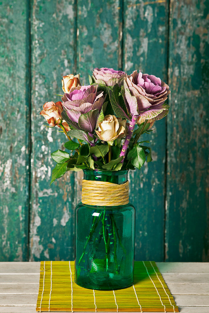 Ornamental cabbage and roses in vase