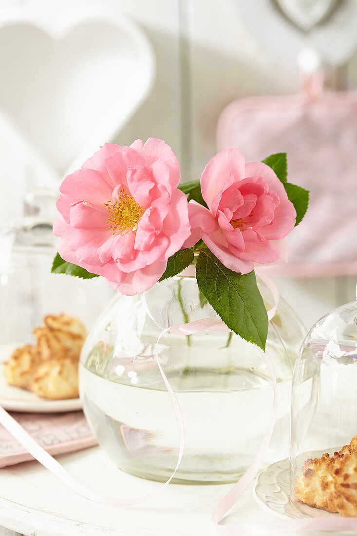 Rosafarbene Rosenblüten in Glasvase