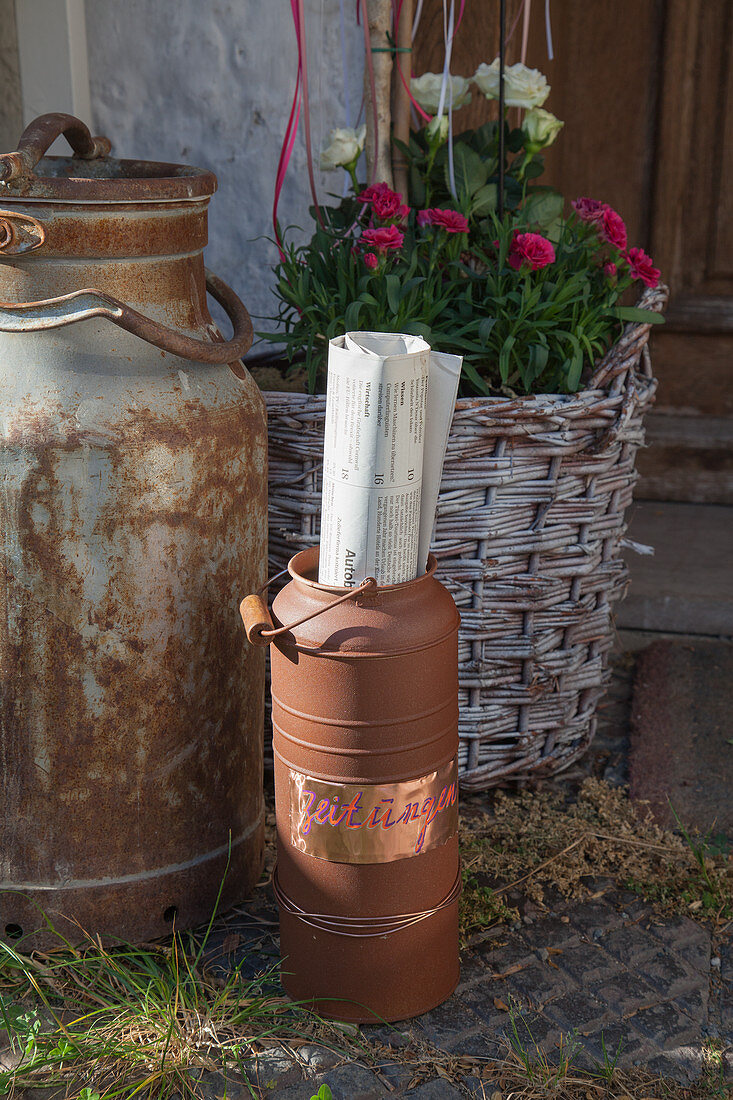 Newspaper holder made from rusty old milk churn