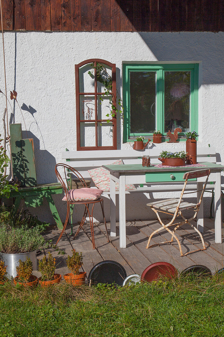 Sitzplatz auf der Terrasse mit rostfarbener Deko am Bauernhaus