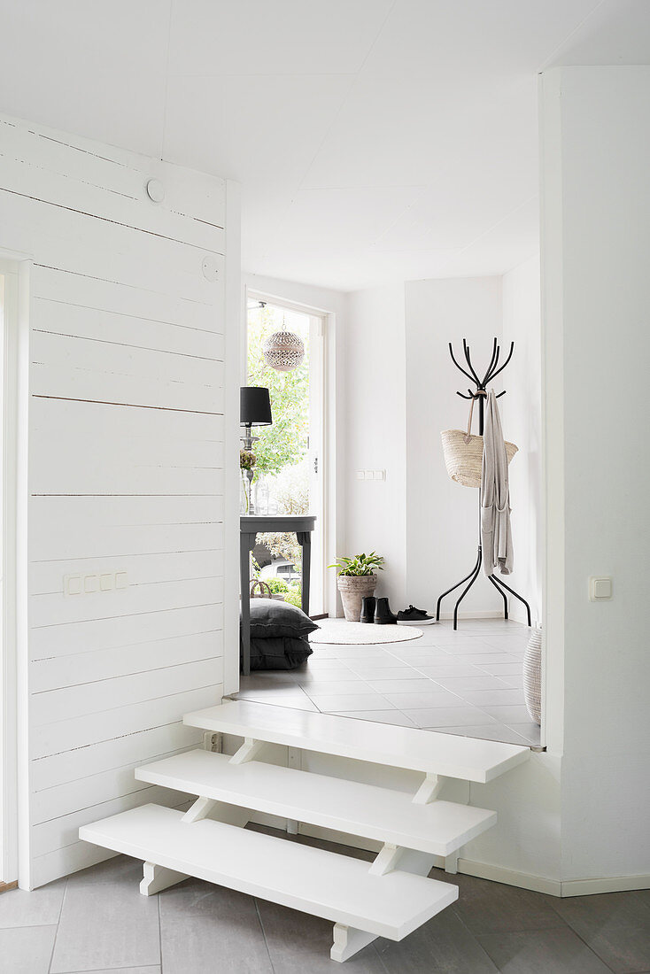 Steps leading from foyer to living space in white interior