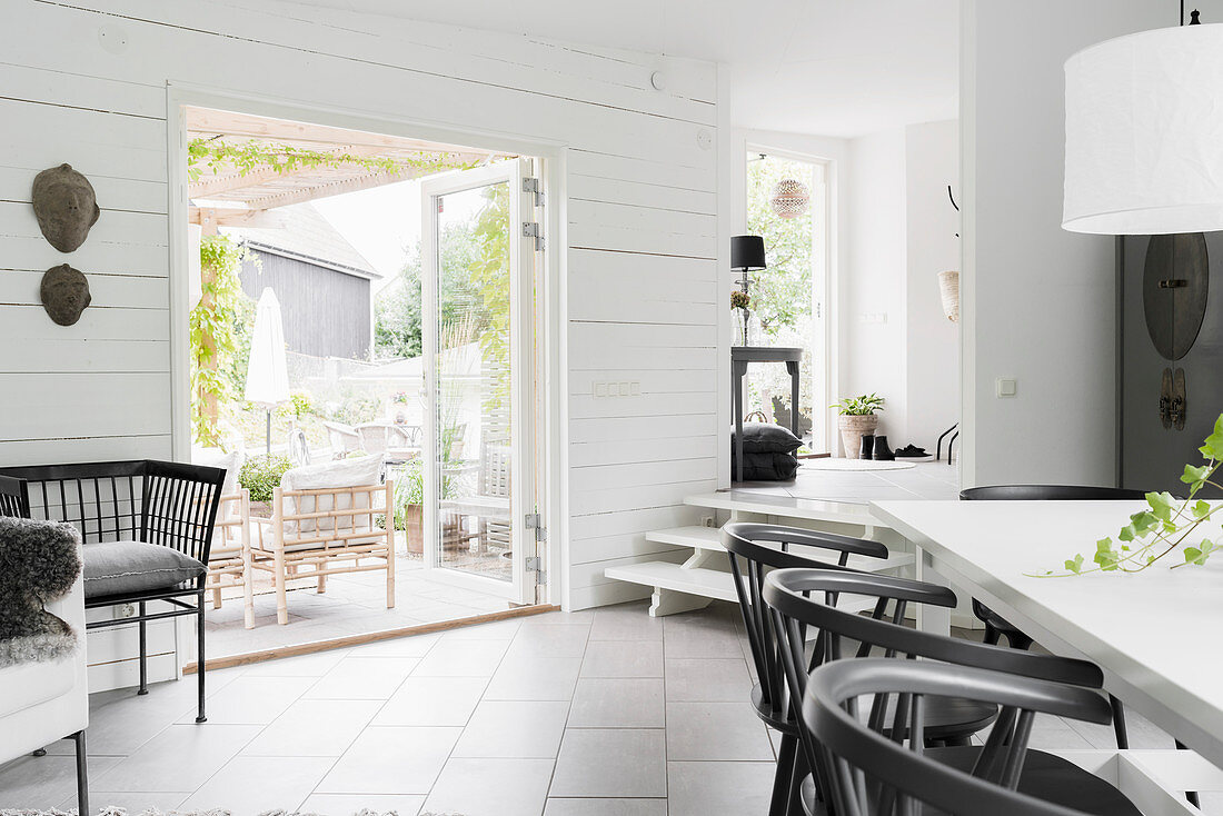 Dining table in black-and-white interior with garden access