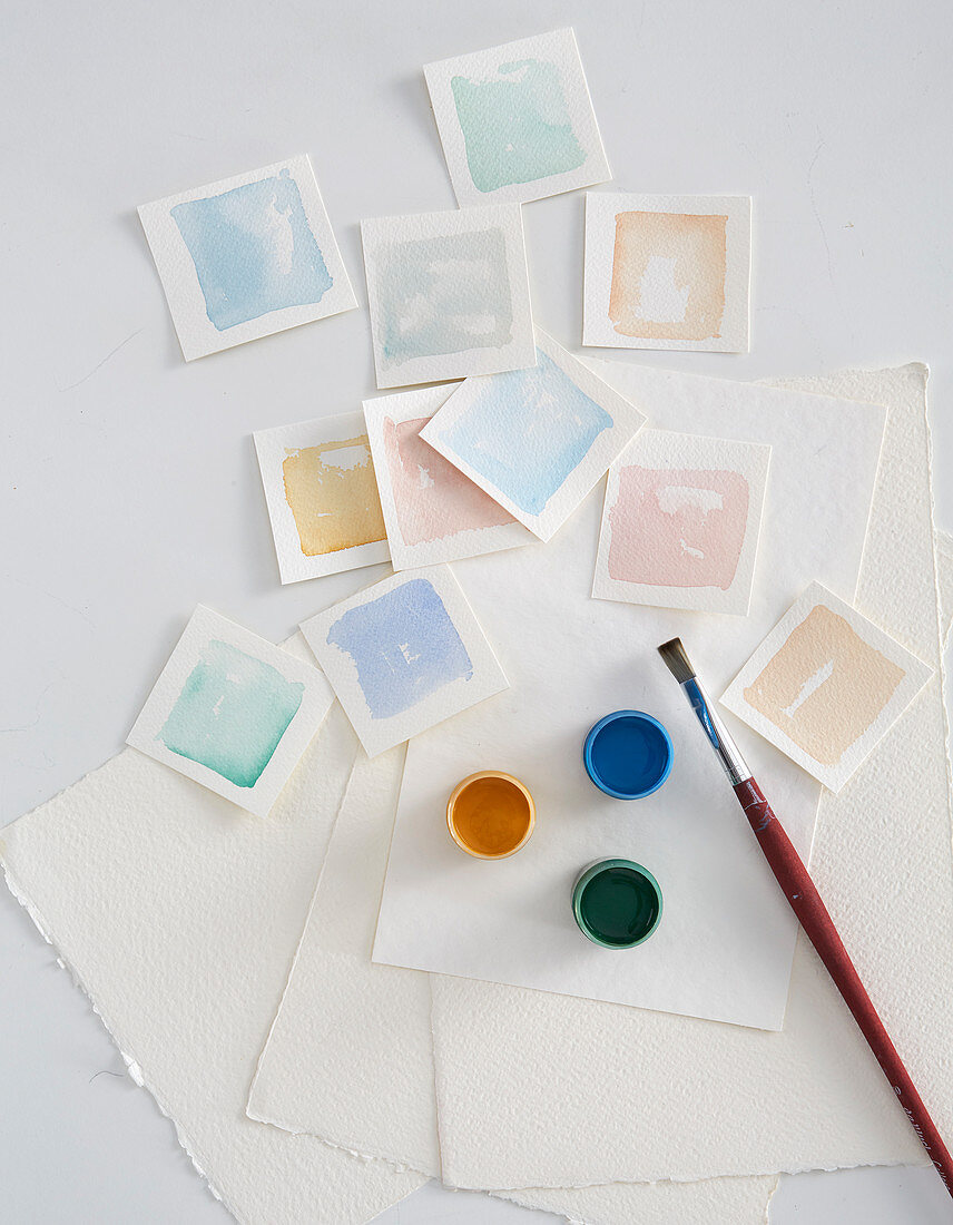 Squares of watercolour paper painted with various watercolour paints