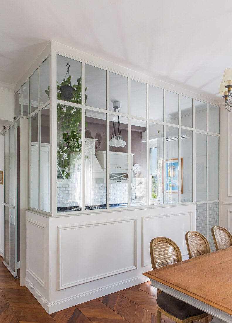 Kitchen separated by glass wall and dining room in classic period building