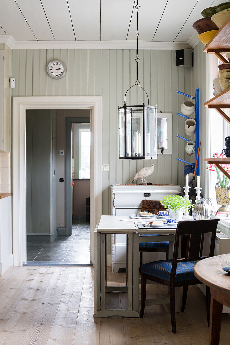 White, drop-leaf dining table below window in kitchen-dining room of renovated Swedish house