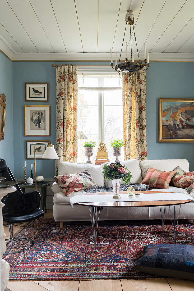 Sofa, coffee table and swivel armchair in living room with blue wall