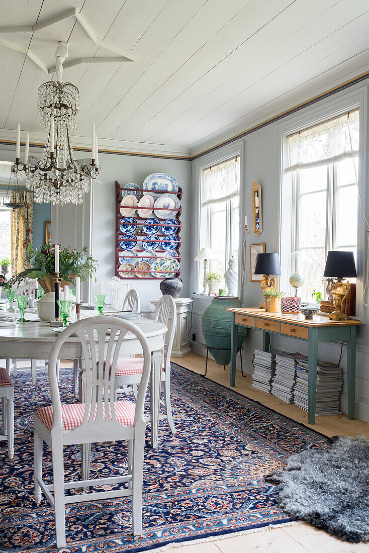 White table, chandelier and Oriental rug in dining room of renovated Swedish house