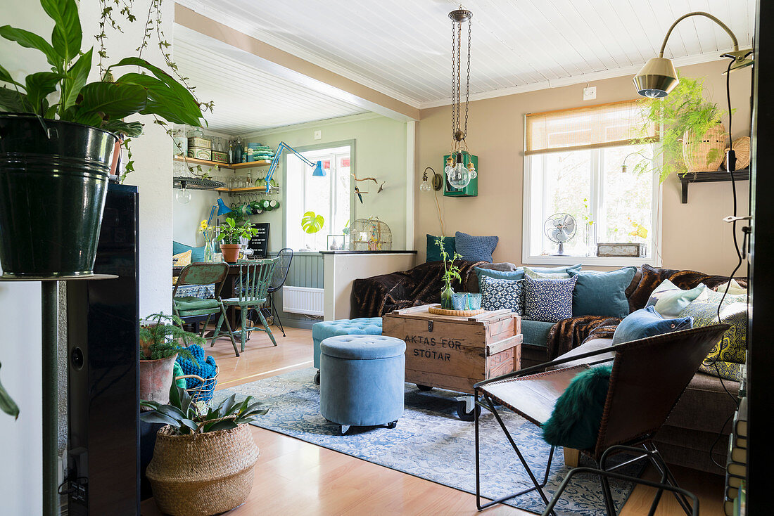 Eclectic mixture of flea-market furniture and houseplants in open-plan interior