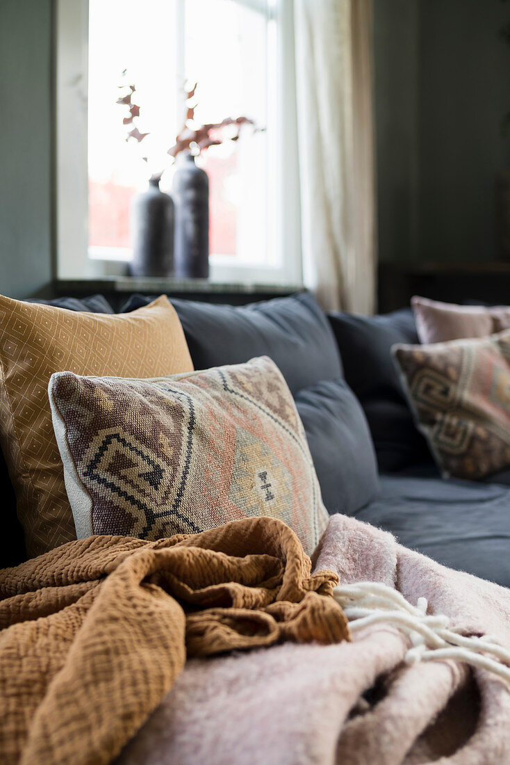 Scatter cushions and blankets on comfortable corner sofa