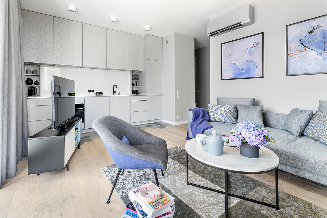 Open-plan interior in shades of grey with purple accents