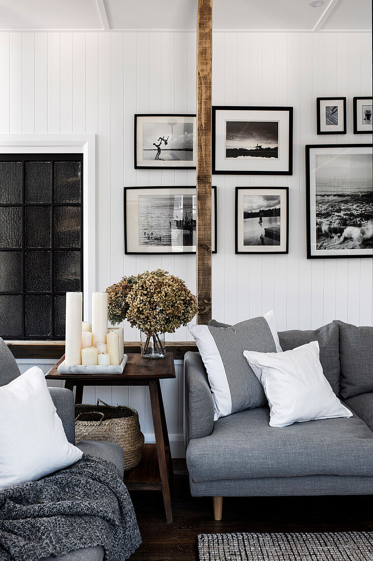 Bilderwand mit Schwarz-Weiß-Fotos im monochromen Wohnzimmer