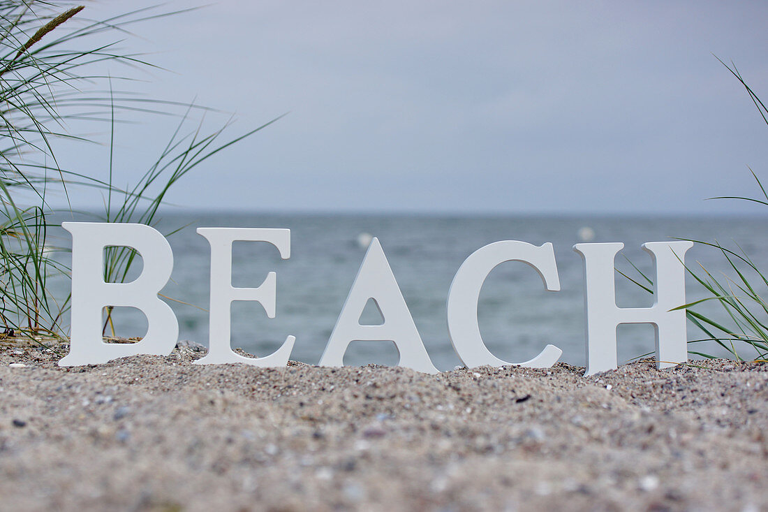 Buchstaben 'BEACH' am Strand