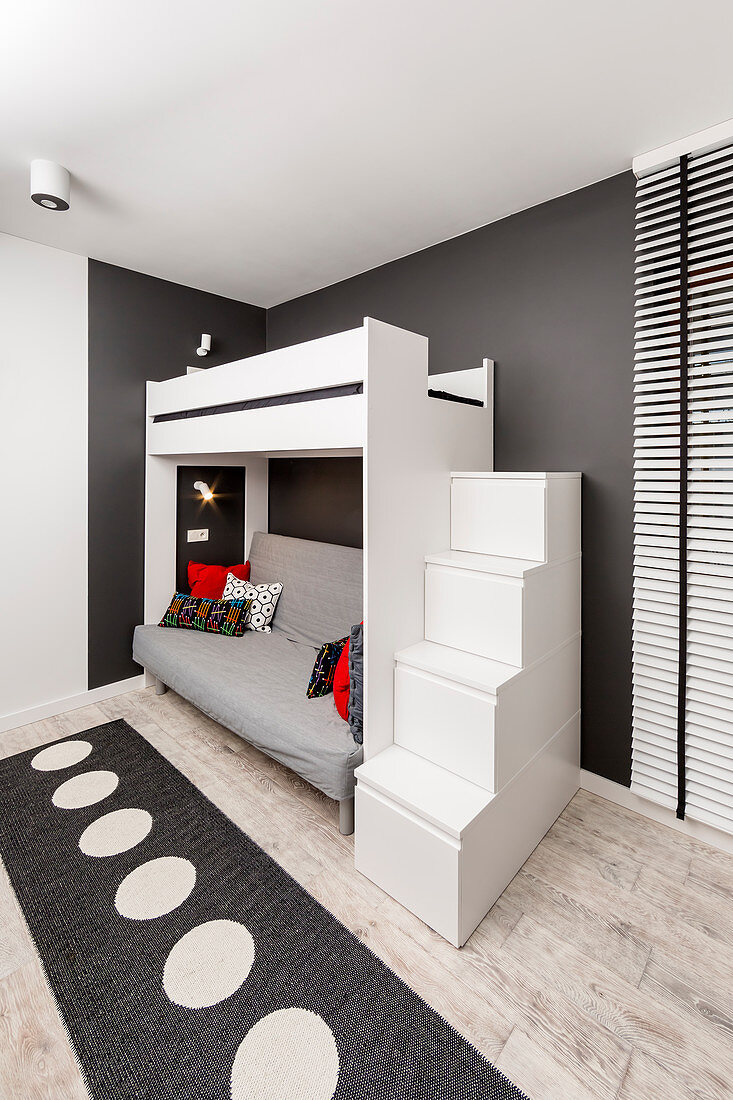 Steps with storage spaces leading to loft bed in black-and-white teenager's bedroom