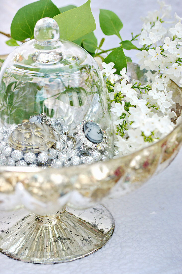 Jewellery under glass cover in bowl of lilac