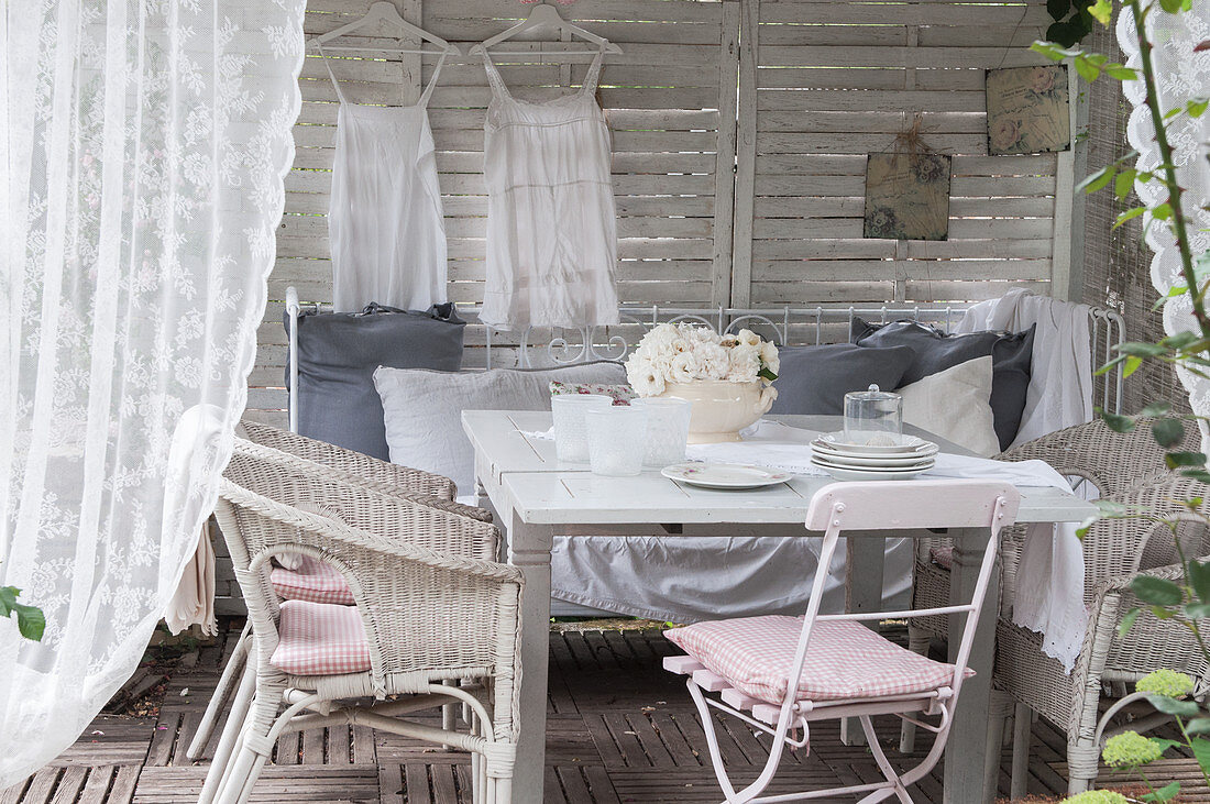 Vintage-style decoration in white wooden pavilion with seating area