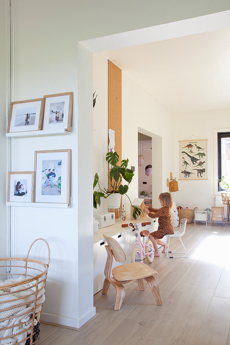 Open doorway leading into playroom with child sitting at sideboard