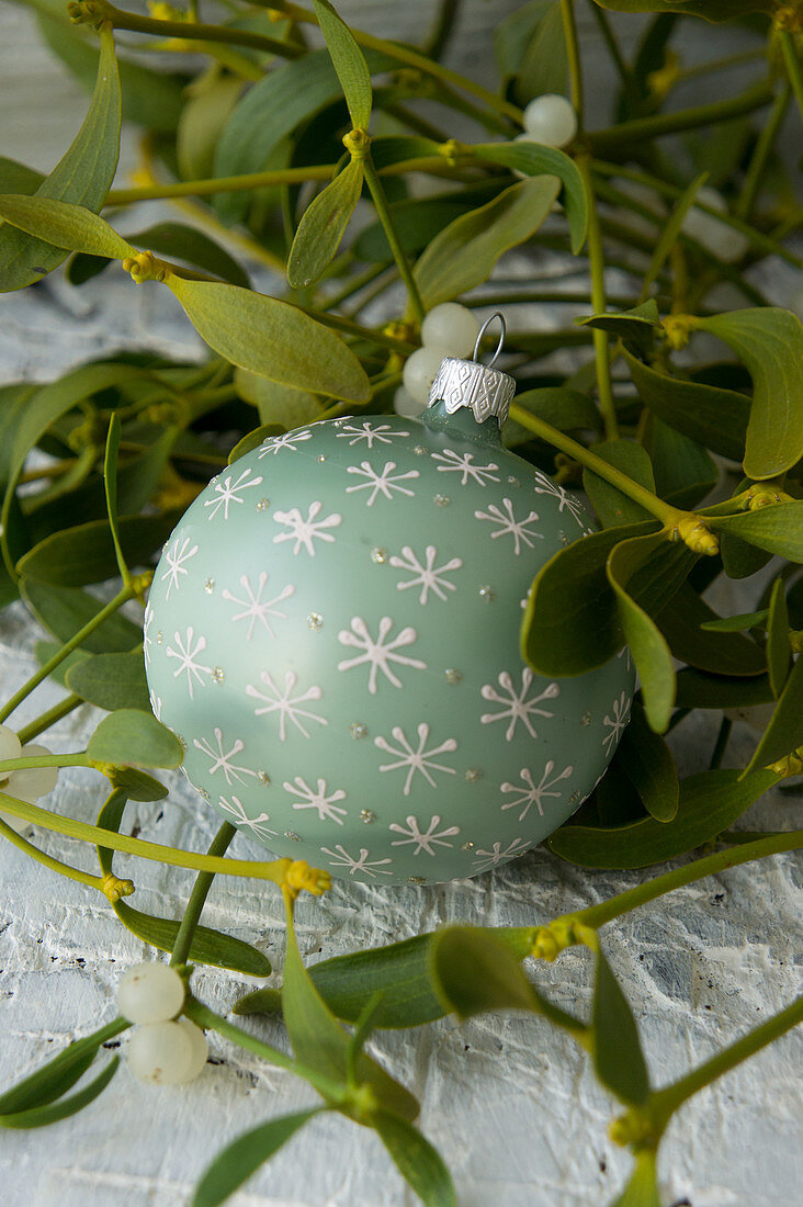 Christmas-tree bauble lying in mistletoe