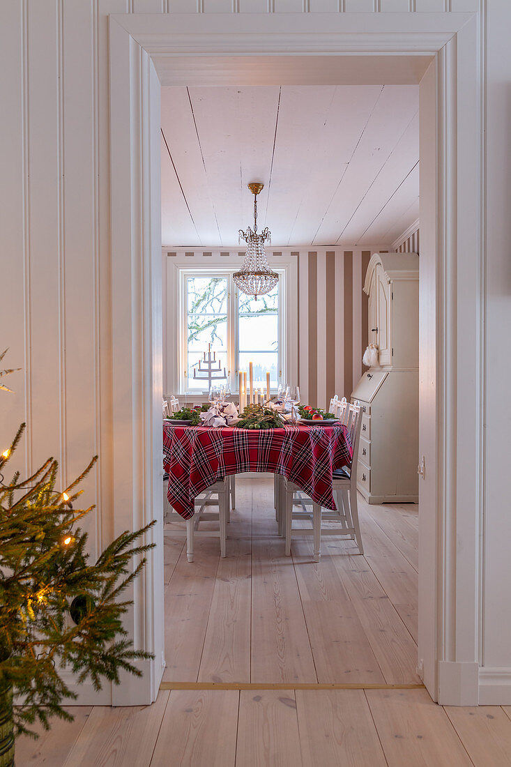 View into Scandinavian dining room with Christmas tree in foreground