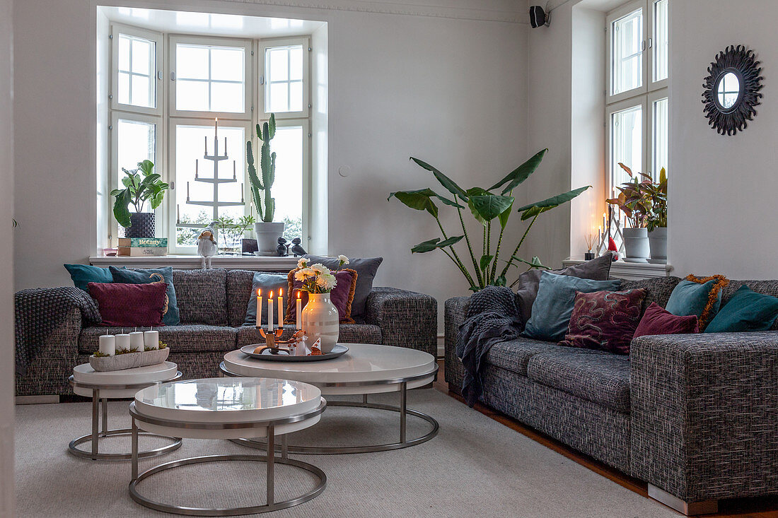 Runde Couchtische im eleganten Wohnzimmer mit Altbaufenstern