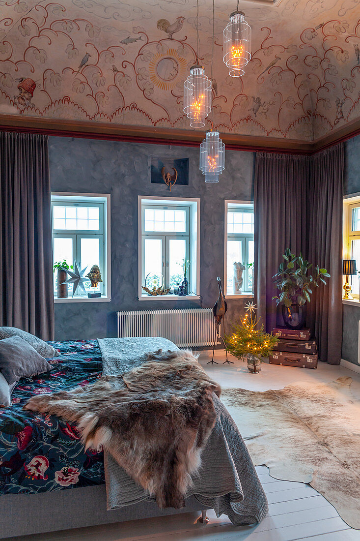 Elegant rustic bedroom with mottled painted wall and ornately painted ceiling