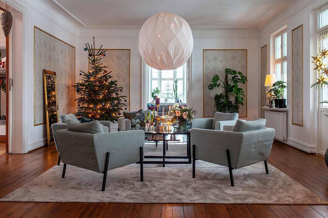 Elegantes Wohnzimmer mit Weihnachtsbaum und blauen Sesseln