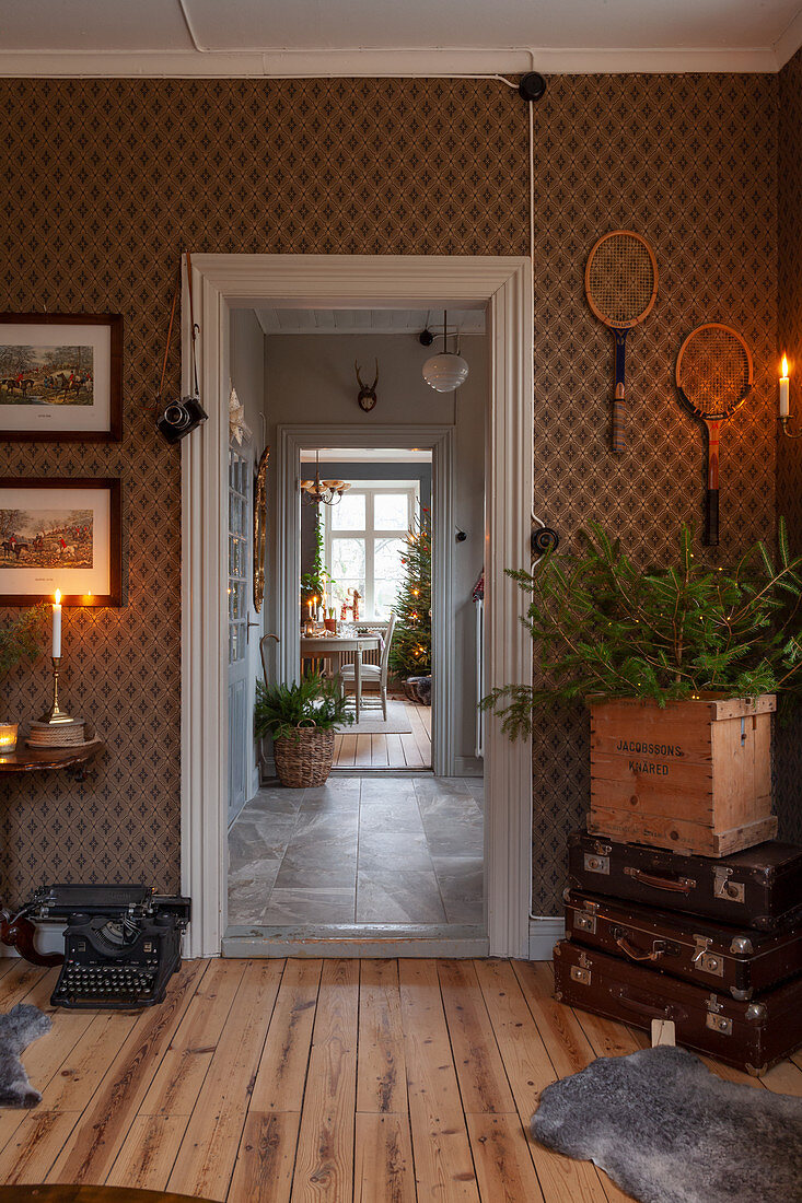 Bilder und Tennisschläger als Wanddeko in Wohnraum mit klassisch gemusterter Wandtapete