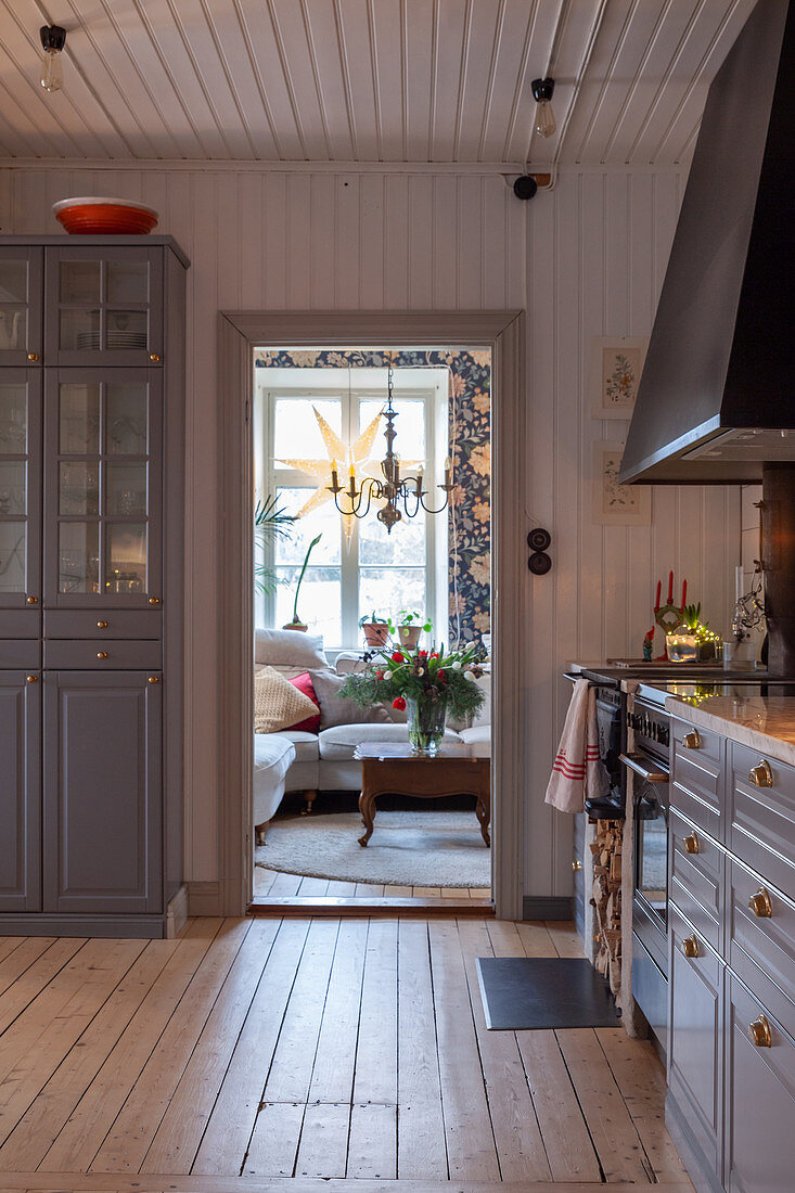 Modern country-house kitchen with blue-grey cupboards, wooden walls and wooden floor