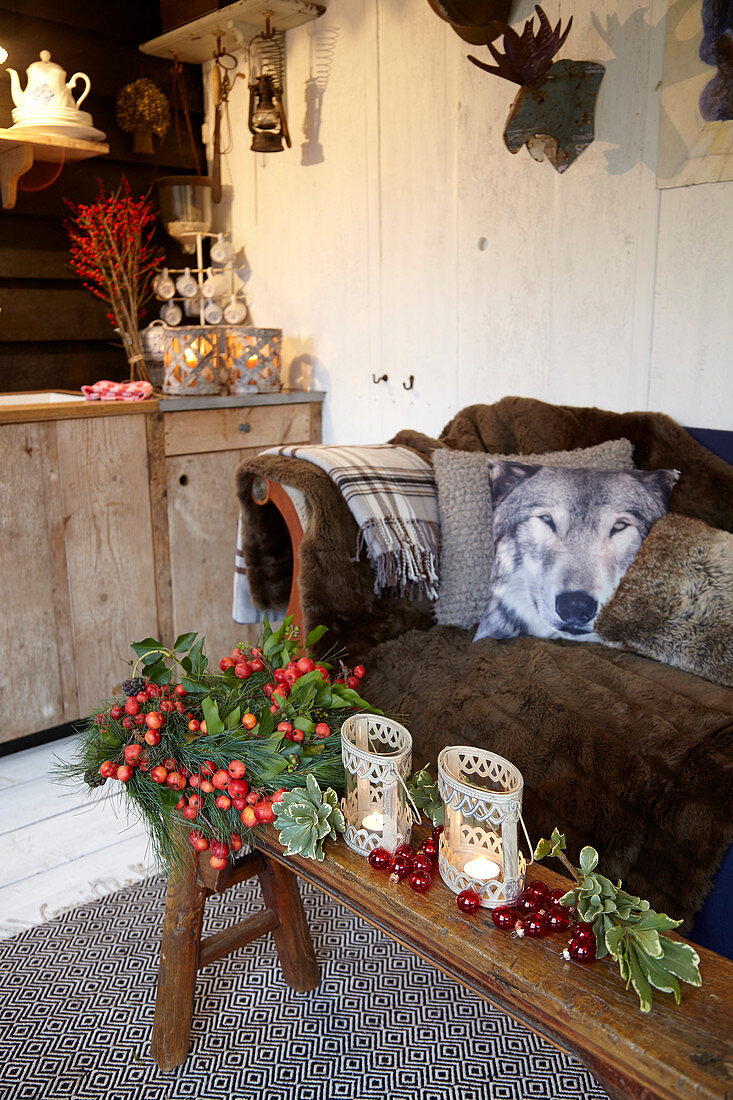 Holzbank mit Weihnachtsdekoration vor Sofa mit Kissen