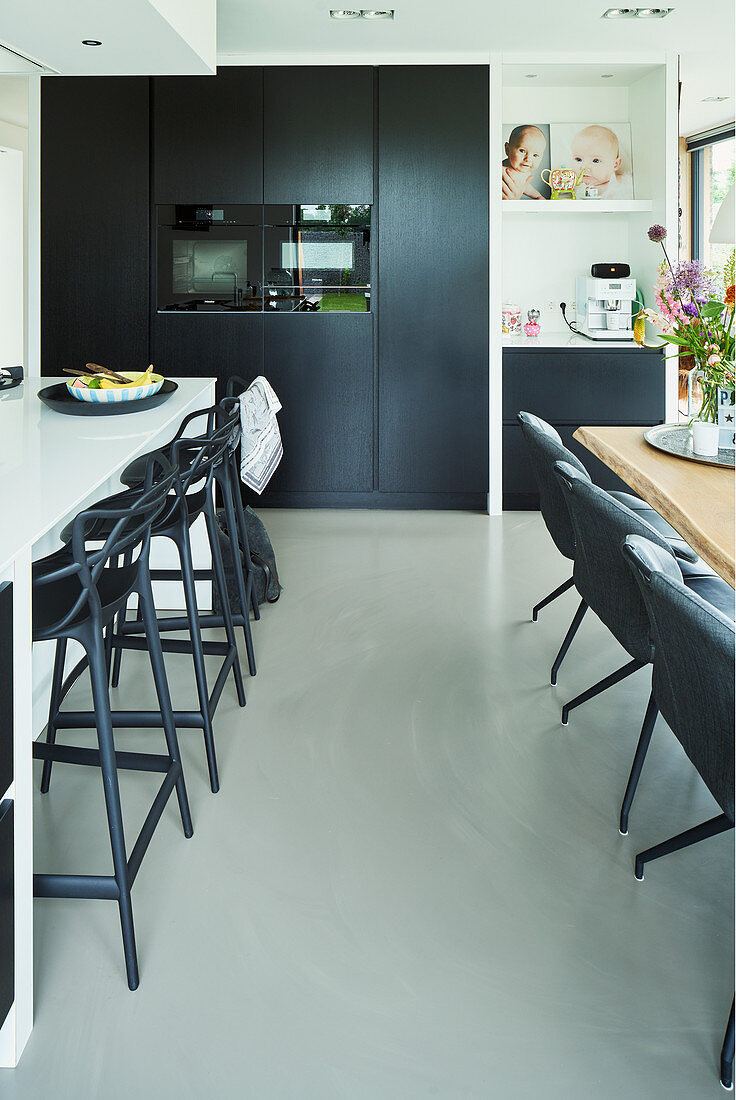 Offener Küchenbereich in Schwarz- Weiß gestaltet mit Frühstückstheke und Esstisch