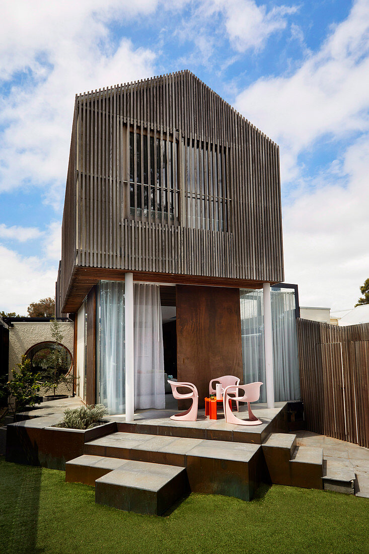 Architektenhaus mit holzverkleidetem Aufbau und kubisch gestaltetem Terrassebereich