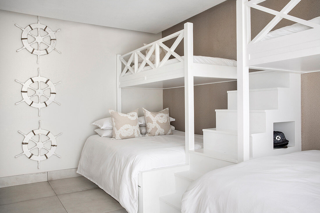 Zwei Etagenbetten mit Treppen im Gästezimmer in Beige und Weiß